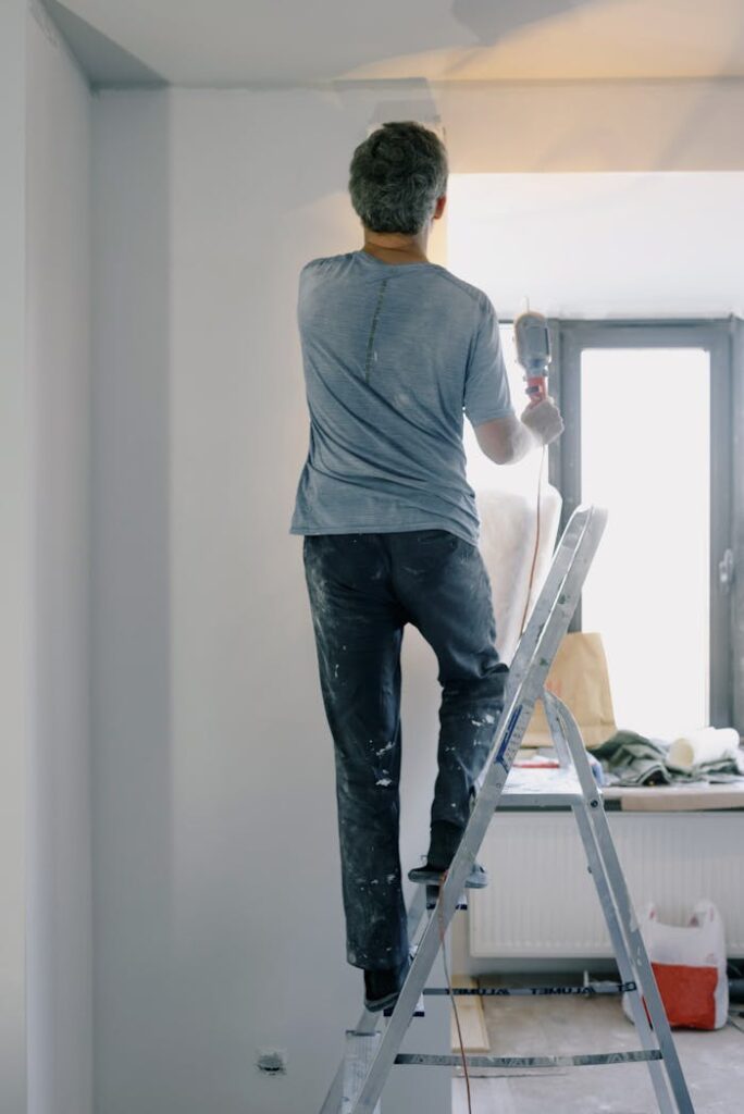 Male builder with instrument in apartment